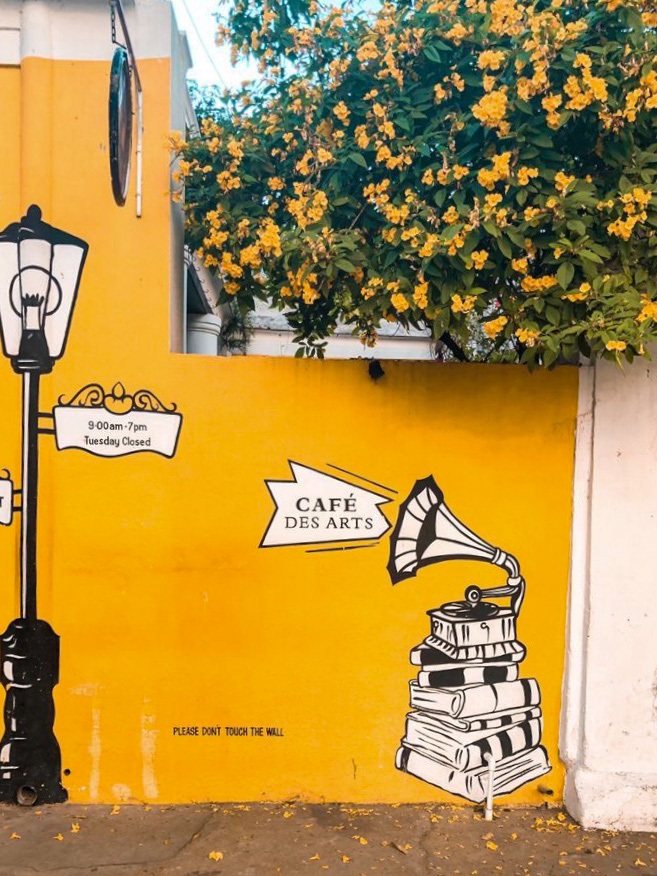 Exterior of the artistic yellow wall at cafe des arts, Pondicherry, India 