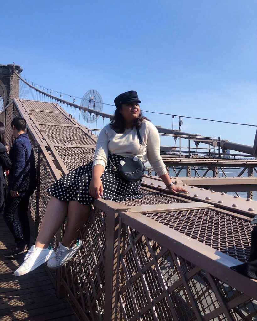 Girl sitting at Brooklyn Bridge in New York 